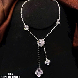 Silver necklace with floral designs on a black stand