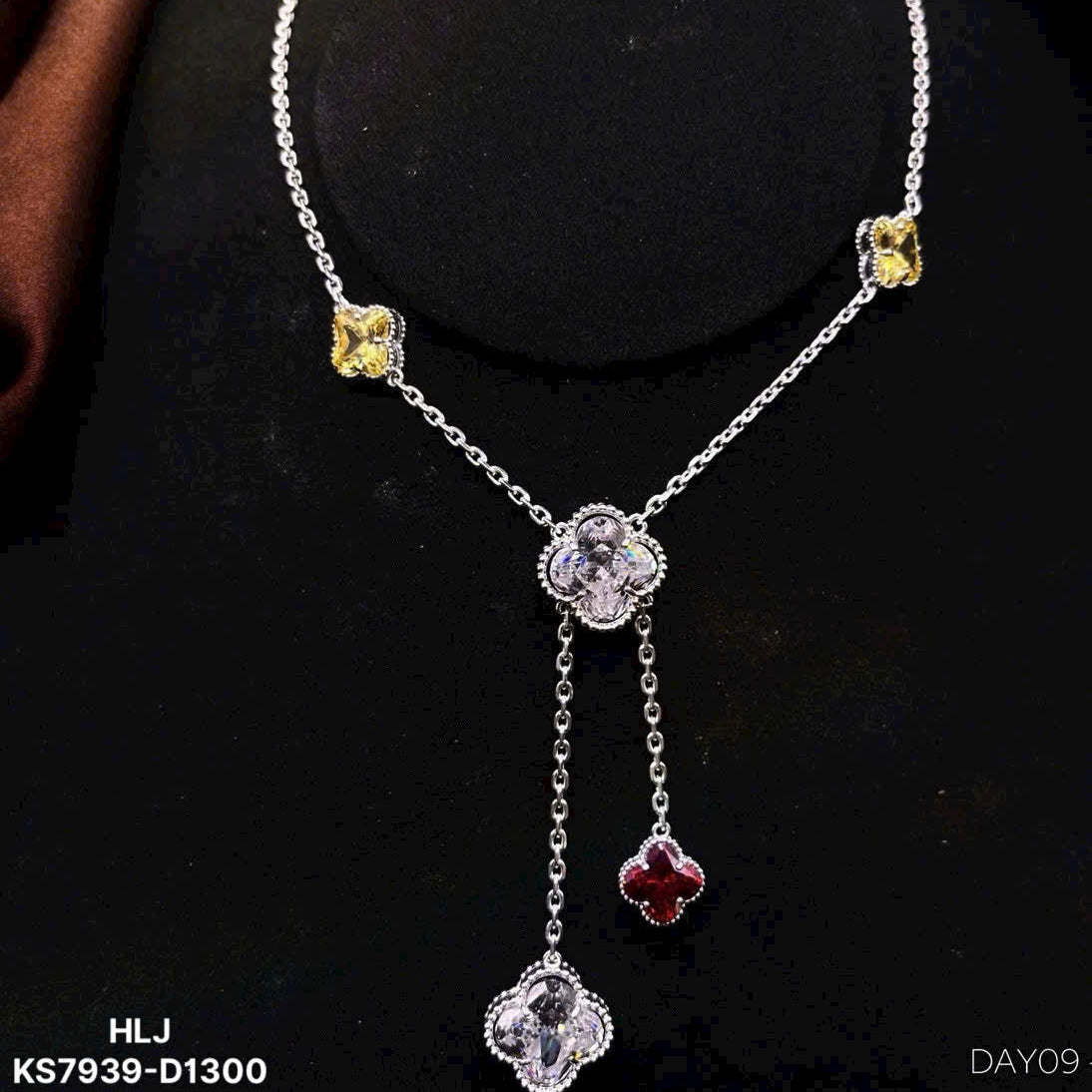 Silver necklace with floral pendants on a black background