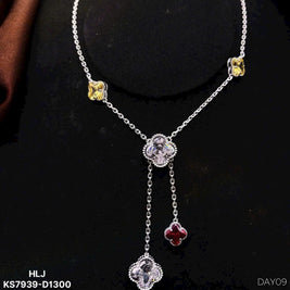 Silver necklace with floral pendants on a black background