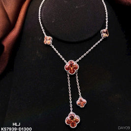 Silver necklace with floral pendants on a black stand