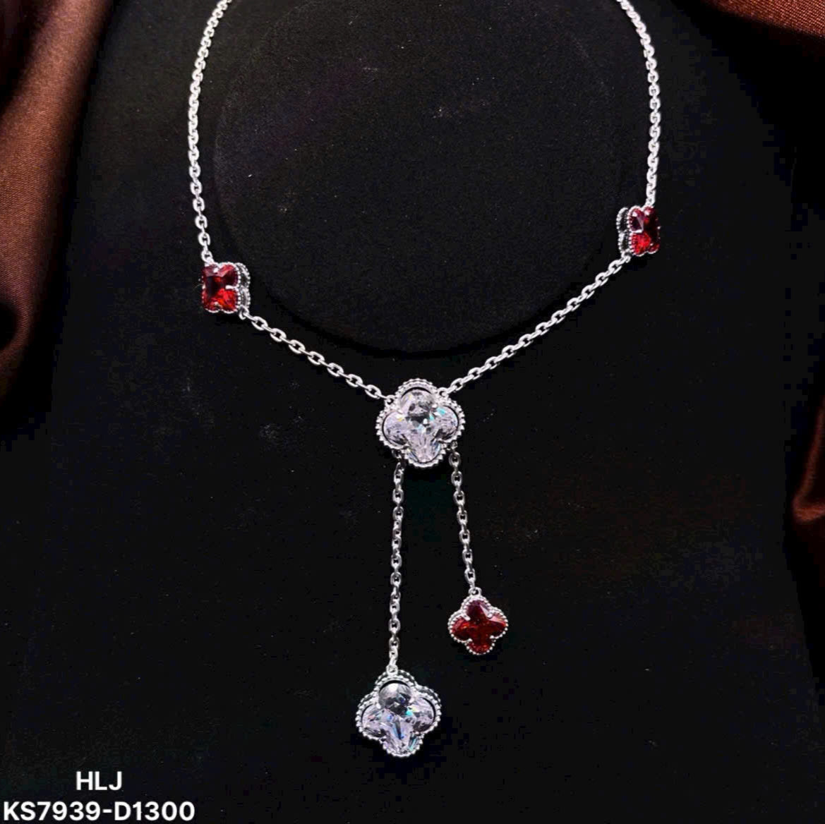 Silver necklace with red gemstones on a black background