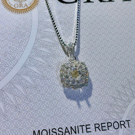 Silver pendant on a chain with 'GRA' branding on a Moissanite report card.