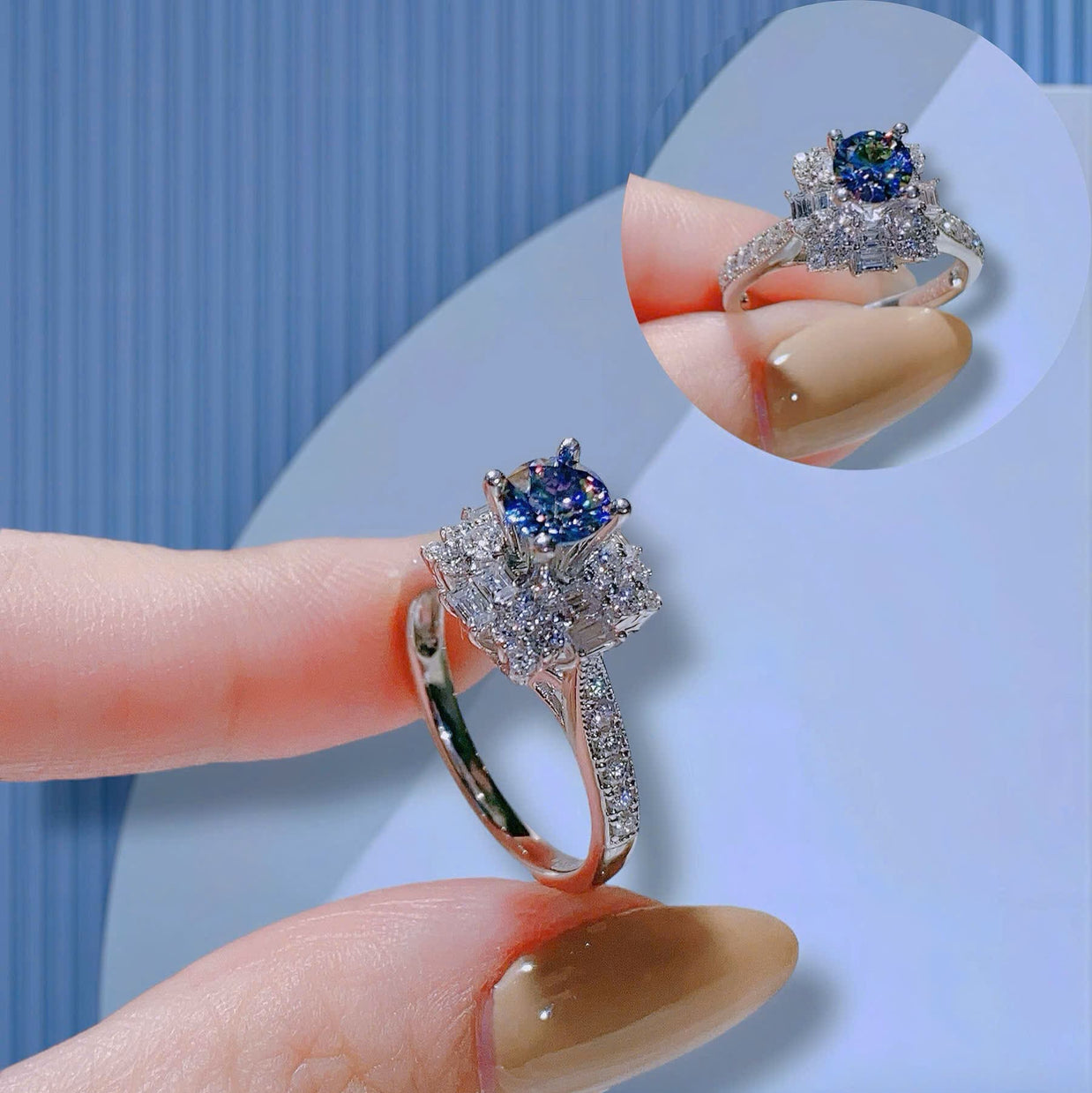 Silver ring with a blue gemstone held by a hand against a light background