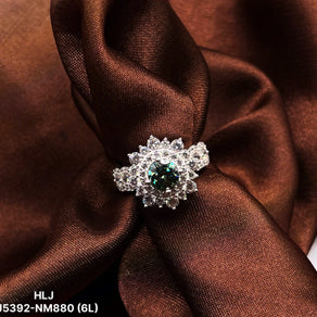 Silver ring with a green gemstone on brown fabric