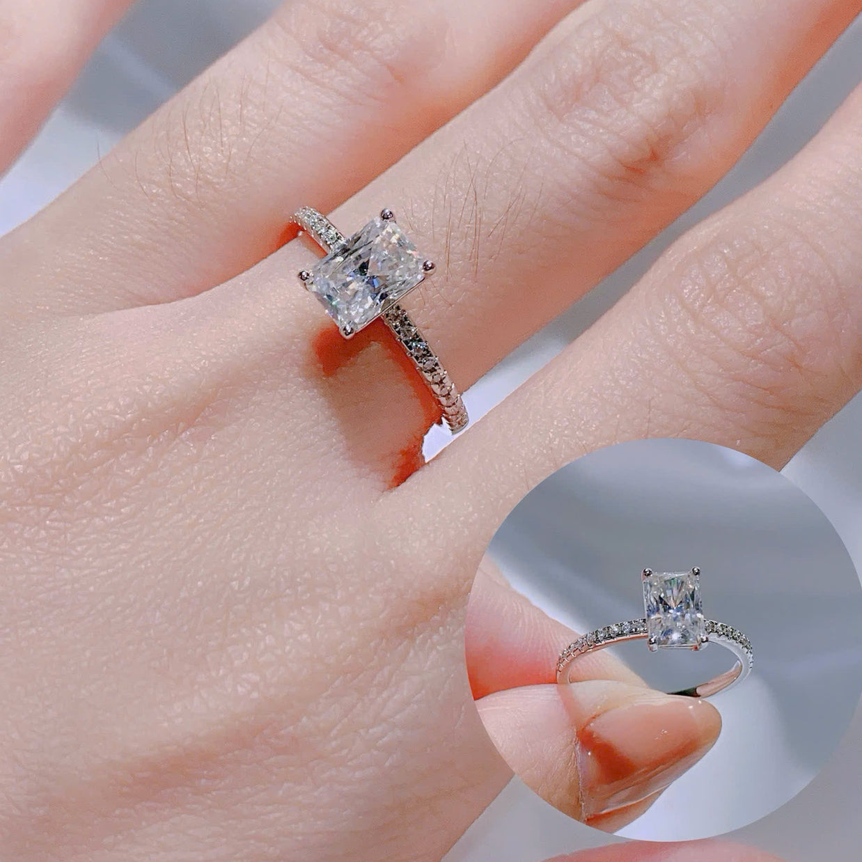 Silver ring with a large diamond on a hand, with a close-up inset showing the ring.