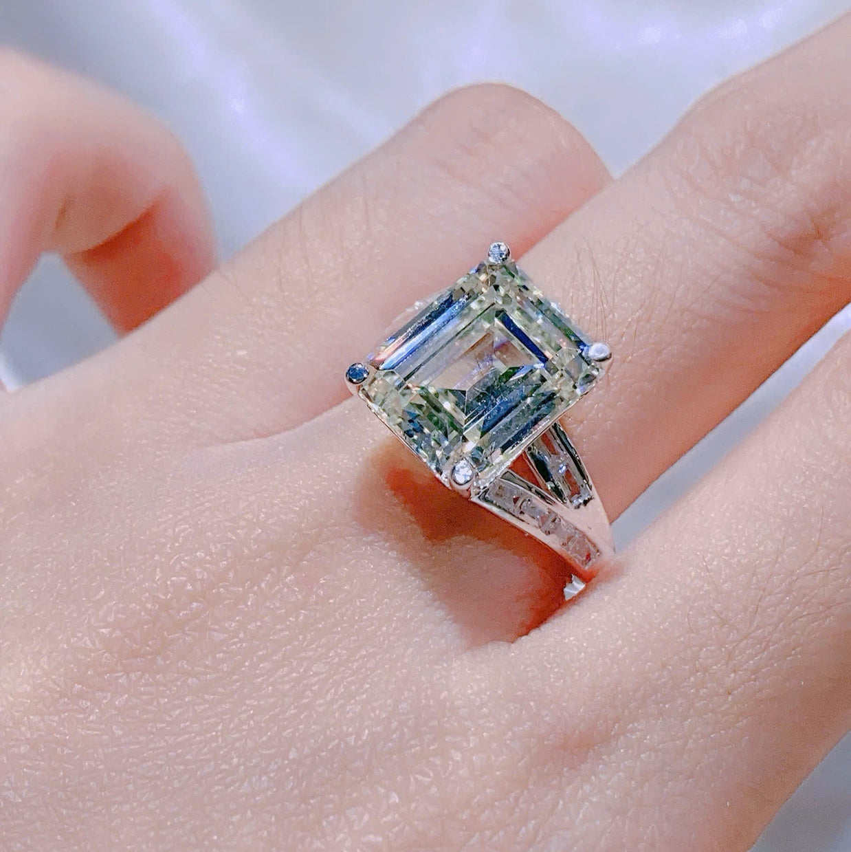 Silver ring with a large rectangular gemstone on a hand