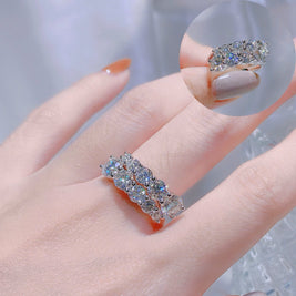 Silver ring with gemstones on a hand against a neutral background