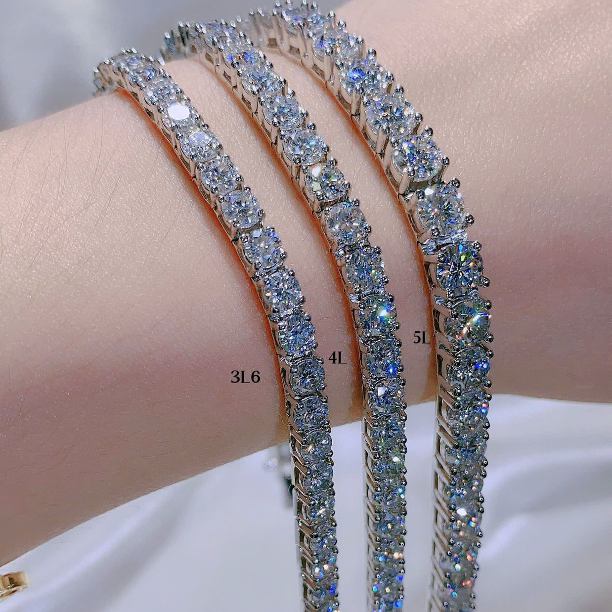 Three diamond bracelets on a person's wrist with a blurred background