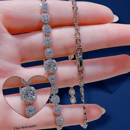 Two diamond bracelets on a hand with a blue background