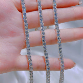 Two diamond bracelets on a hand with a blurred background
