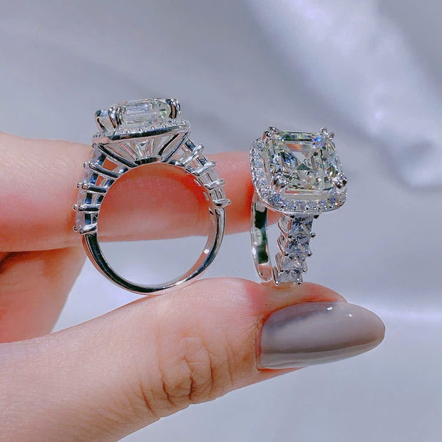 Two diamond rings held between fingers against a neutral background