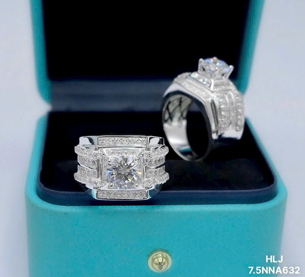 Two diamond rings in a turquoise box with a visible brand logo.