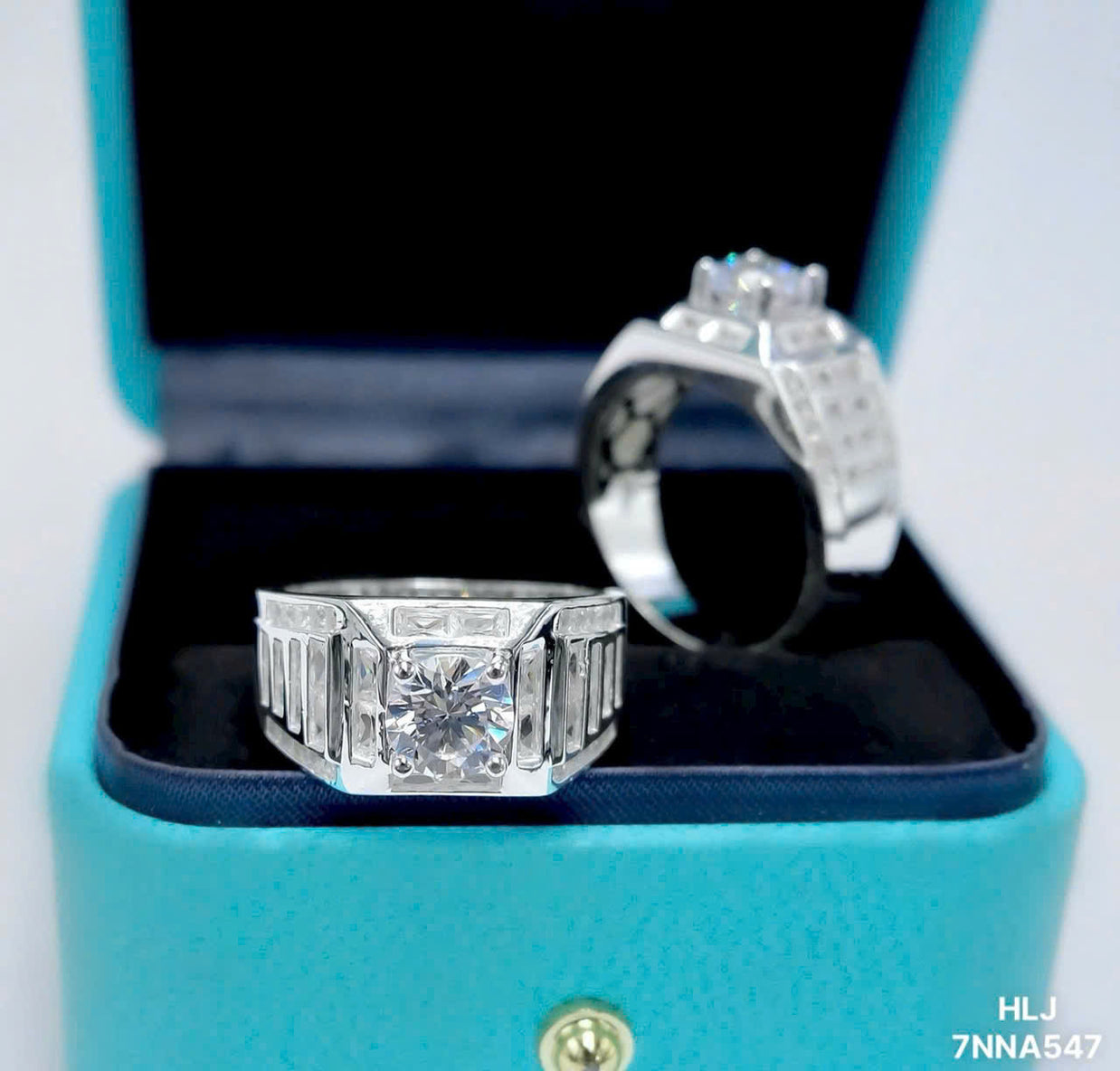 Two diamond rings in a turquoise box with a visible brand logo.