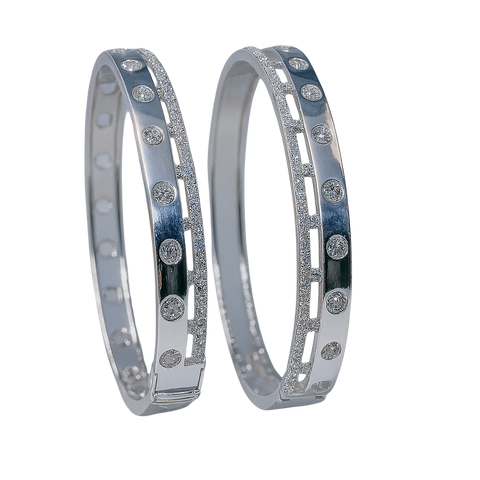 Two silver bangles with embedded stones on a white background