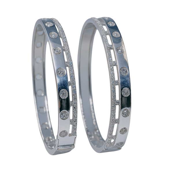 Two silver bangles with embedded stones on a white background