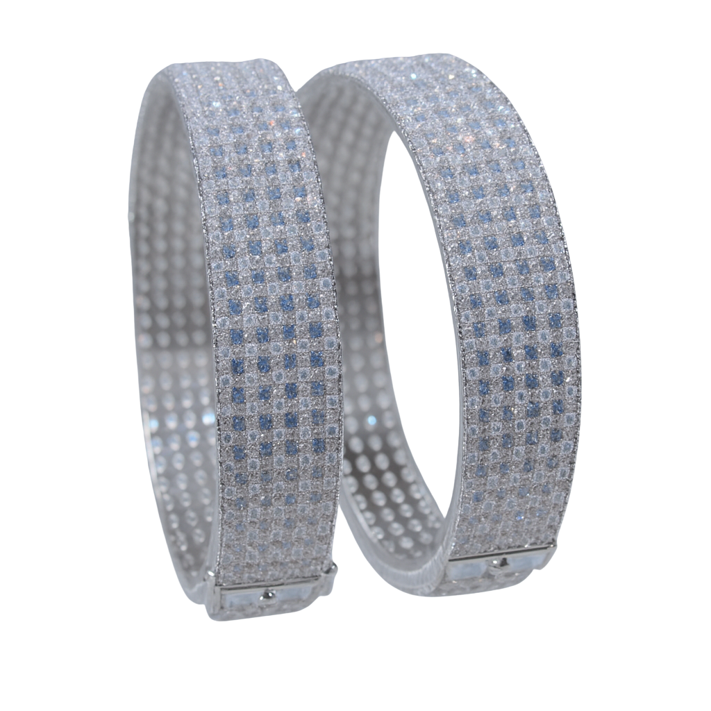 Two silver bracelets with blue gemstones on a white background