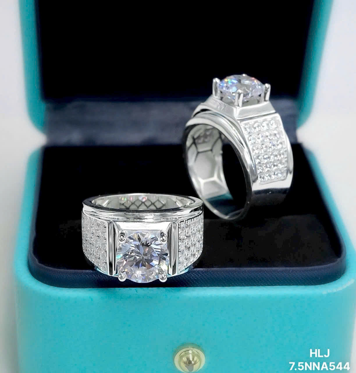 Two silver diamond rings in an open blue box.