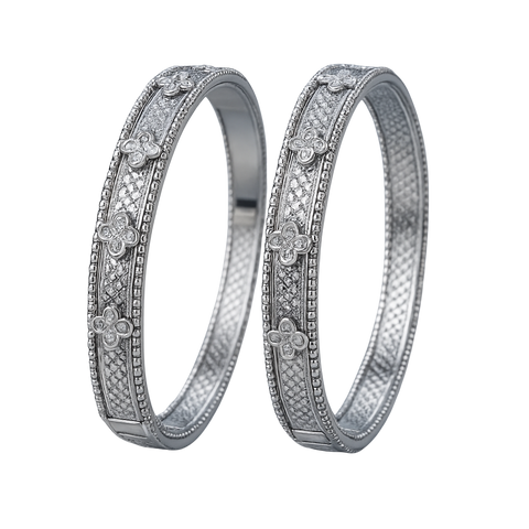 Two silver rings with floral and diamond designs on a white background