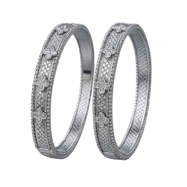 Two silver rings with floral and diamond designs on a white background