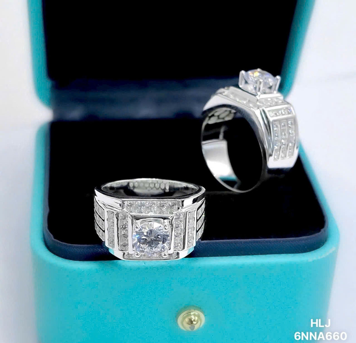 Two silver rings with gemstones in a blue box on a white background