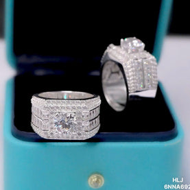 Two silver rings with gemstones on a turquoise stand.